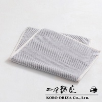 兩條淺灰色棉麻混紡人字紋快乾浴墊，一條疊在另一條上面，邊緣有白色滾邊。