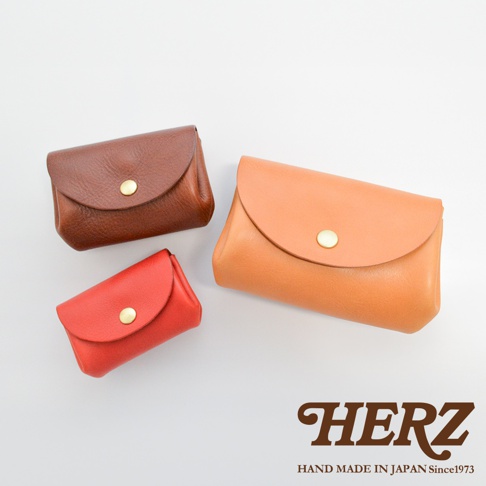 職人手作皮革三層收納零錢包，展示三種不同尺寸與顏色：深棕色、橘色及紅色。皆為皮革材質，設有金色按扣。