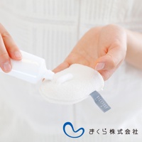 白色的 iimin 蠶絲洗臉手套，質地柔軟，上面擠有白色洗面乳。手套一角縫有淺灰色品牌標籤。