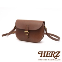 職人手作皮革經典馬鞍包，採用深棕色皮革製作，配有金色釦環和可調式肩帶，風格簡潔實用。