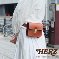 經典棕色皮革腰包，附有金色金屬鎖扣，由職人手工製作。