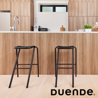 兩張黑色金屬吧檯椅，椅面為弧形凹槽設計，椅腳為細長金屬管構成，椅面與椅腳皆為黑色。