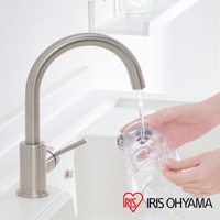 銀色金屬水龍頭，下方接有透明集塵筒，水流正從水龍頭注入集塵筒。