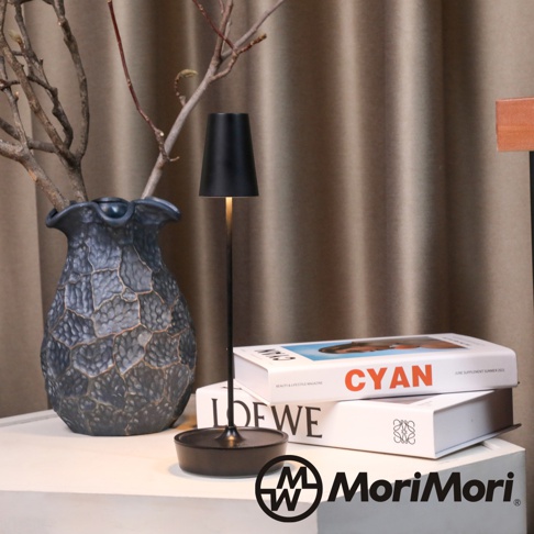 黑色金屬復古氛圍燈，圓形底座，燈罩呈錐形，搭配乾枯樹枝和一個深灰色帶紋理的花瓶，背景為棕色布簾。