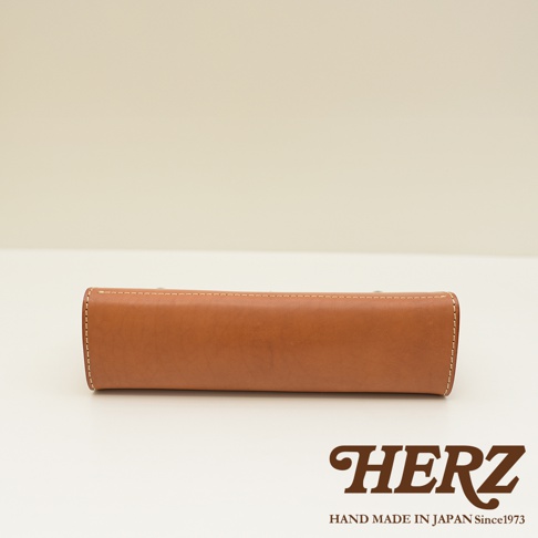 職人手作皮革復古口金兩用手提包 P-8，呈現焦糖棕色皮革，包身線條簡潔，搭配米白色縫線，展現細膩工藝。