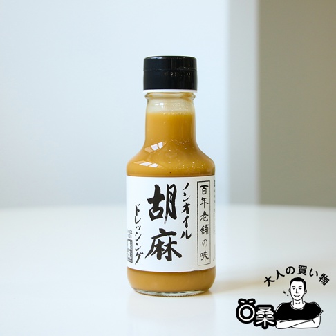 玻璃瓶裝無油芝麻沙拉醬，醬汁呈淡棕色，瓶蓋為黑色。瓶身貼有白色標籤，上面印有中文「胡麻」及日文「ノンオイル」等字樣。