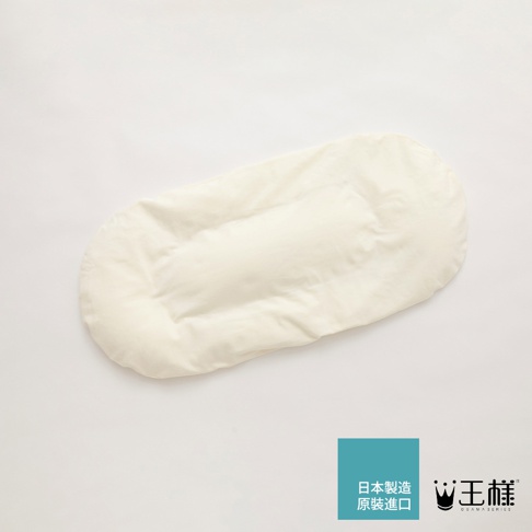 一個米白色的王樣腰枕，外層為柔軟布料，內部填充物使其呈現立體凹凸感，形狀類似長橢圓形，側邊縫有車線。