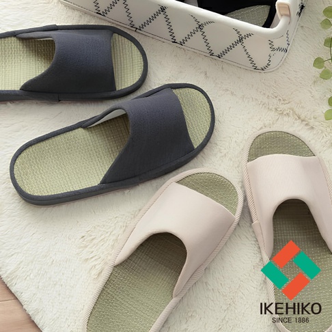 三雙藺草透氣室內拖鞋，兩雙深灰色，一雙淺粉色，鞋面為織物材質，鞋底為藺草編織，放置於白色絨毛地毯上。