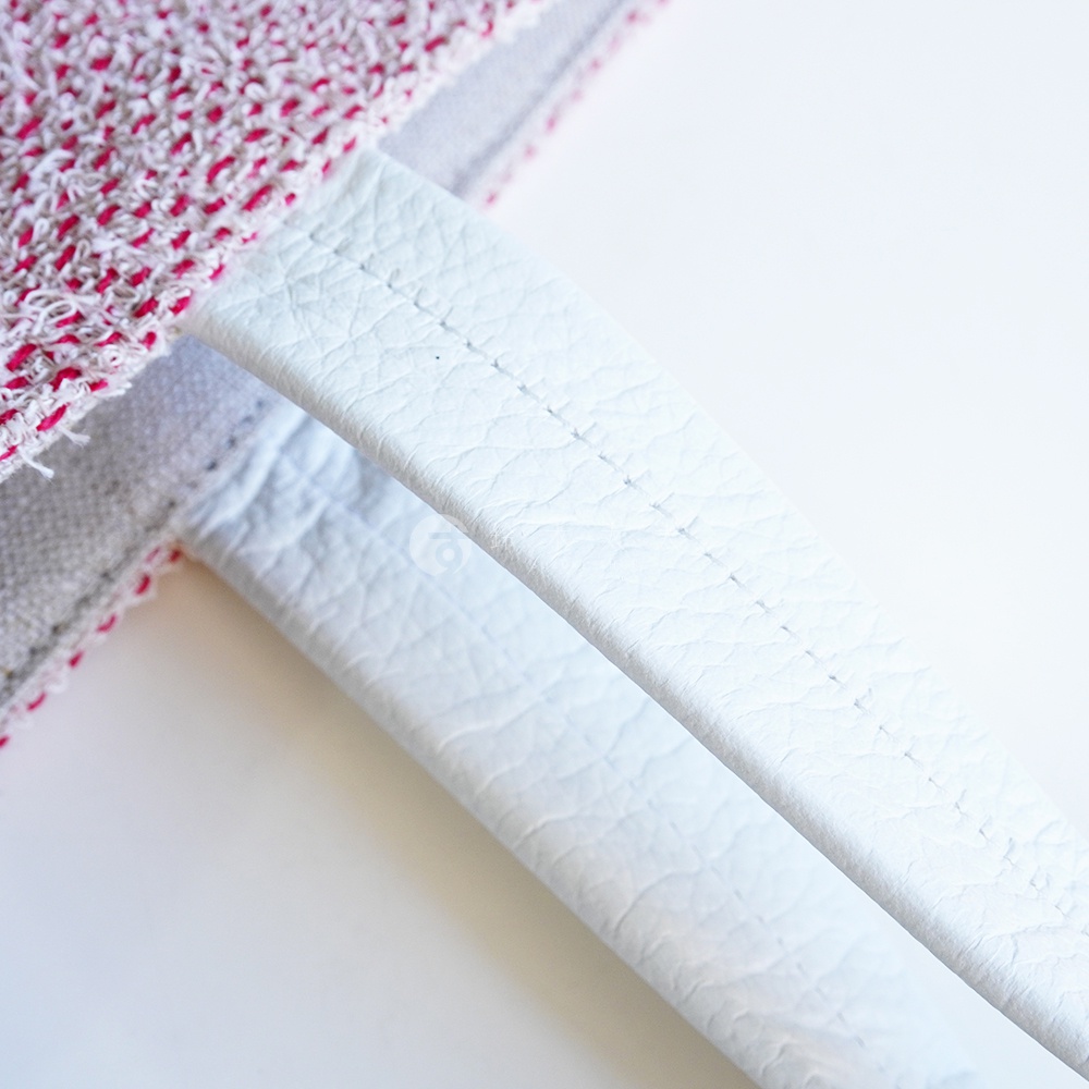 BAN INOUE 蚊帳棉裂織手提袋的細節，特寫了織物與皮革提把的縫線。