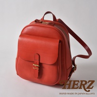 紅色皮革迷你後背包，帶有立體前袋，皮革帶扣和金色拉鍊。