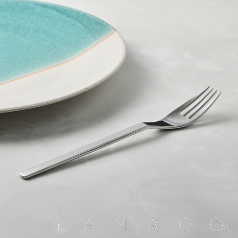不鏽鋼叉，盤子一角為藍色漸層，白色邊緣，整體為極簡風格。