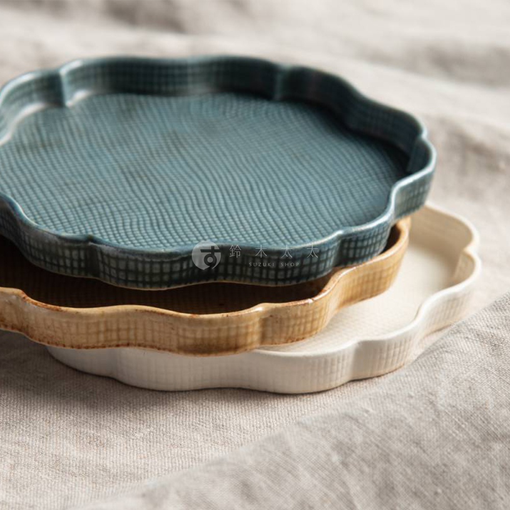 三層堆疊的花型甜點盤，最上層為藍綠色，中間為淺棕色，最下層為米白色。盤子表面皆有細緻的紋理，邊緣呈現波浪狀。