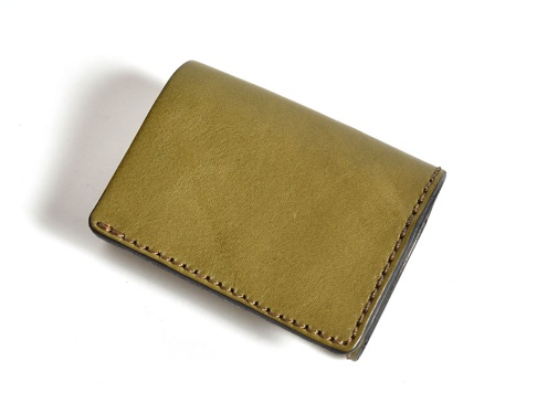 橄欖綠色皮革三折式迷你短夾，表面光滑，車縫線整齊。