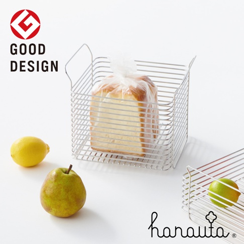 不鏽鋼深型收納籃，採線條網格設計，內有裹著透明塑膠袋的吐司，籃子旁擺放著一顆黃色檸檬和一顆綠色梨子。