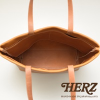 職人手作的淺棕色皮革托特包，內部有四個開放式口袋，簡潔設計，適合日常使用。