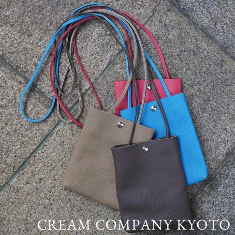 三款京都職人手作隨身手機包，材質為荔枝紋皮革，顏色為大地色、粉紅色和藍色，搭配細長同色系背帶。