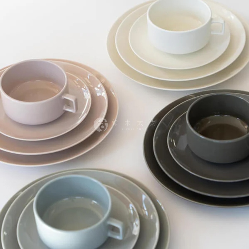 四組美濃燒圓餐盤，分別為粉色、白色、深灰色及淺灰色，每組包含一個杯子和疊放的盤子，材質為陶瓷。