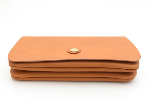 淺棕色皮革製的長夾，側邊可見多層結構，中央有一個金色按扣。