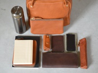 Mサイズ収納例:水筒、小物入れ・ポーチ(GS-2-M)、文庫本、ブックケース(GS-37-S)、A5ノート、ギボシ留め縦型キーケース(GS-23)、縦型パスケース(GS-24)、iPhone、ペンケース(GS-28-S)、ラウンドファスナー長財布(GS-27)