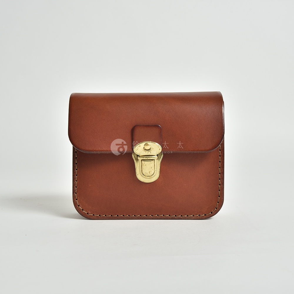 經典棕色皮革腰包，方形設計，附有黃銅色鎖扣，手工縫線。