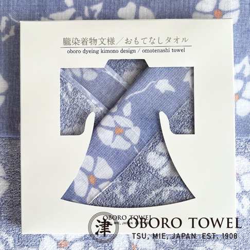 津OBORO 朧染和紋款待之心紗布毛巾，白色禮盒包裝，展示著淺藍色和服造型的毛巾，印有白色花卉圖案