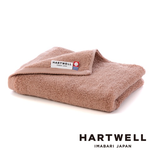 一條粉棕色純棉毛巾，質地蓬鬆，帶有「HARTWELL IMABARI JAPAN」品牌標籤。