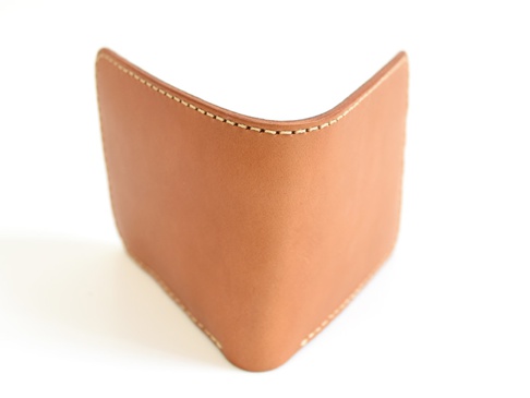 職人手作皮革經典掀蓋扣式雙折短夾 (WS-5)，採用天然棕色皮革製作，邊緣縫線細緻，呈現簡約設計。