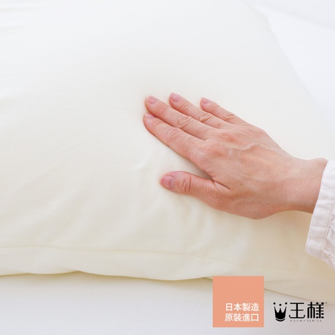 米白色「王樣の雙面BIG夢枕」專用枕套，觸感柔軟，一隻手輕壓在枕套上，展示其蓬鬆感。