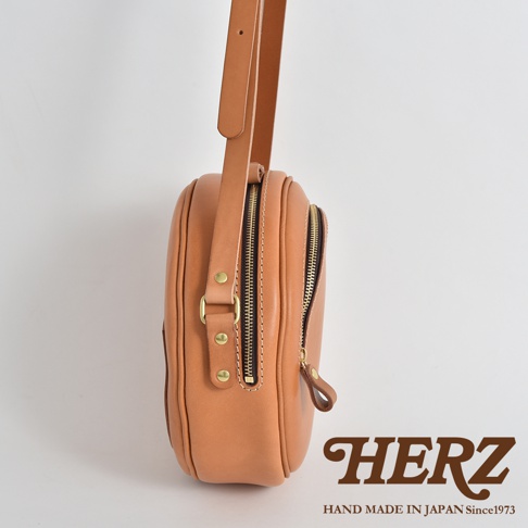 職人手作皮革小圓包 CK-19 S，呈現天然皮革的溫潤色澤，側面可見雙拉鍊設計，搭配金屬扣環與精緻縫線，展現簡約質樸的風格。