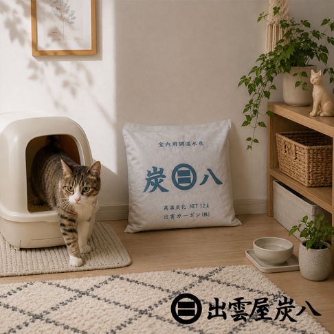 一隻虎斑貓正從白色的貓砂屋中走出，地板上放置著一個印有出雲屋炭八字樣的方形除濕木炭袋，背景為簡約溫馨的室內居家環境，右側木架上擺放著植栽與裝飾品，右下角則有出雲屋炭八的品牌標誌。