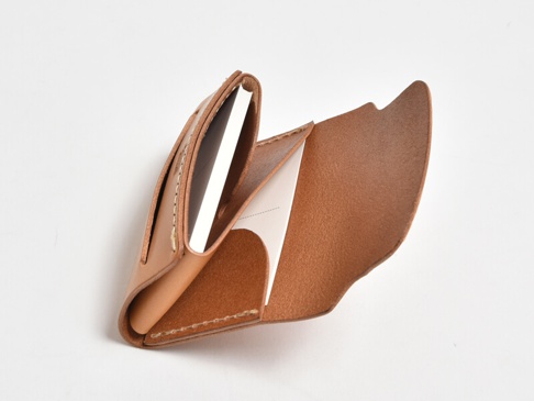 職人手作皮革迷你卡片收納夾 (KV-2) 是一款淺棕色皮革製品，設計簡潔，有幾個卡槽，可收納卡片。皮革表面光滑，縫線清晰，展示了精細的手工藝。