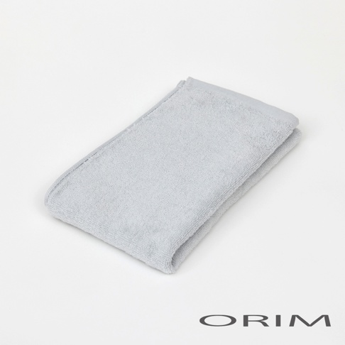 淺灰色柔軟迷你毛巾，材質為純棉，織有細緻紋理，邊緣有縫線。