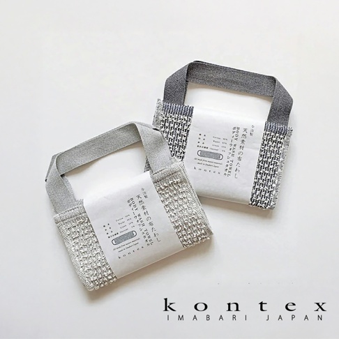 兩條天然素材製成的按摩洗澡巾，有淺灰色和灰黑色兩款，皆為標準尺寸，採用織紋布料，附有品牌標籤。