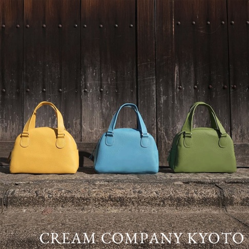 三款京都職人手作半月迷你手提包，分別為亮黃色、天藍色與草綠色。皮革材質，造型圓潤，配有雙提把，簡約優雅。
