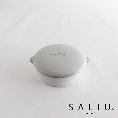 The chef 圓形陶瓷鍋，附有蓋子，呈現淺灰色，鍋蓋上印有「The Chef」字樣，兩側有小提把。