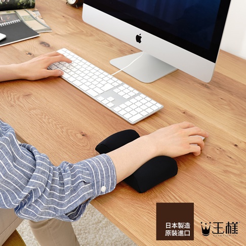 黑色減壓護腕枕，柔軟材質，提供手腕支撐，搭配電腦使用。