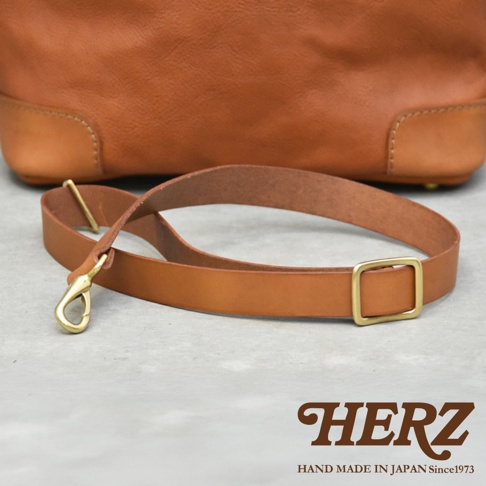 HERZ 職人手作皮革兩用托特包的棕色皮革背帶，配有金色鉤扣和方框。
