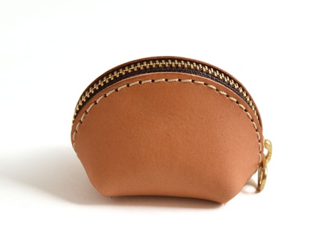 職人手作皮革貝殼造型零錢包，淺棕色皮革，頂部有金色拉鍊，縫線清晰，附有金色鑰匙圈。