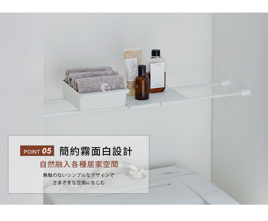 白色霧面材質的伸縮桿置物盒，安裝於牆面之間的兩支平行白色伸縮桿上，盒內整齊收納三條灰色毛巾。置物盒旁搭配兩塊小型白色層板，上方放置瓶裝保養品與洗沐用品，整體呈現簡約清爽的居家收納風格，設置於洗衣機上方空間，展現極簡霧面白色設計自然融入居家環境的視覺效果。