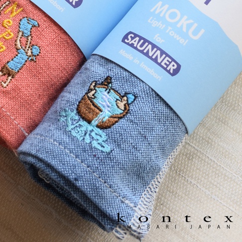 兩條 SAUNNER MOKU 薄輕長精繡桑拿浴巾，一條為珊瑚粉色，另一條為淺藍色，皆有精緻刺繡圖案。