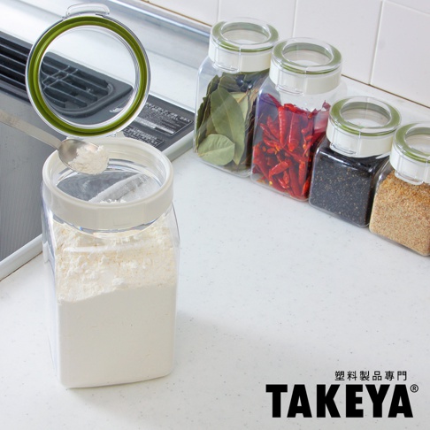 透明塑膠角型收納罐，內裝白色粉末，罐蓋開啟，附有綠色密封圈。後方有數個同款收納罐，分別裝有乾燥香料葉、乾辣椒、黑芝麻及麵包粉。