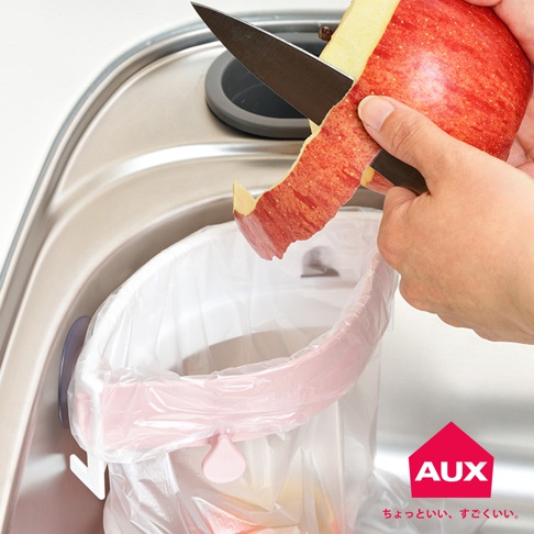 粉色開合式流理台廚餘架，可固定垃圾袋，方便削皮，上方為不銹鋼流理台。