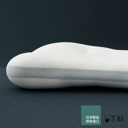 白色天絲 TENCEL 枕頭，側邊有灰色織帶裝飾，枕面有凹槽設計，背景為深藍色。