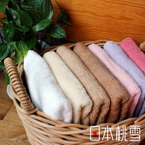 一籃精梳棉飯店毛巾，包含白色、米色、棕色、粉色、紫色和桃紅等顏色，材質蓬鬆柔軟。