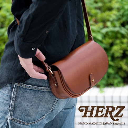 職人手作皮革迷你馬鞍包，採用經典馬鞍造型，天然皮革材質，呈現溫潤的棕色光澤，設有小巧的皮扣，適合斜背或肩背。