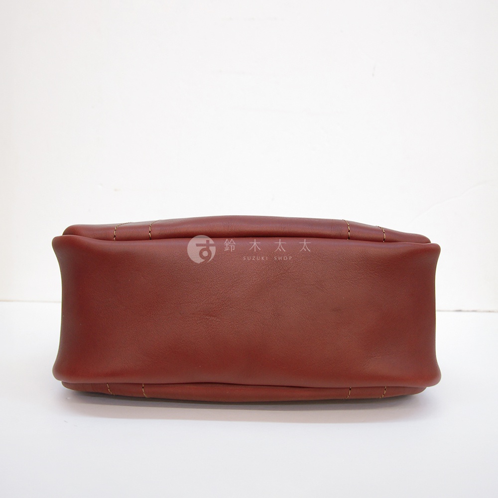 深紅色皮革仕女托特包，包底平整，邊緣有縫線裝飾。