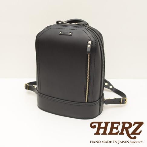 黑色皮革立體商務後背包，設有金色拉鍊和品牌標誌。