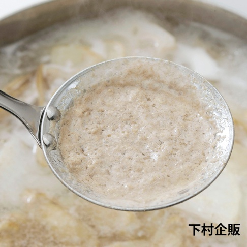 金屬材質的火鍋雜質濾網匙，匙面盛有正在滾動的湯水及浮沫。