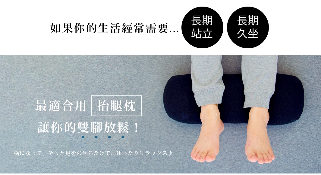 深藍色圓柱形抬腿枕，枕面上方放置著一雙穿著灰色長褲的腿部，腳踝和腳部裸露，枕頭擺放在灰色背景上。