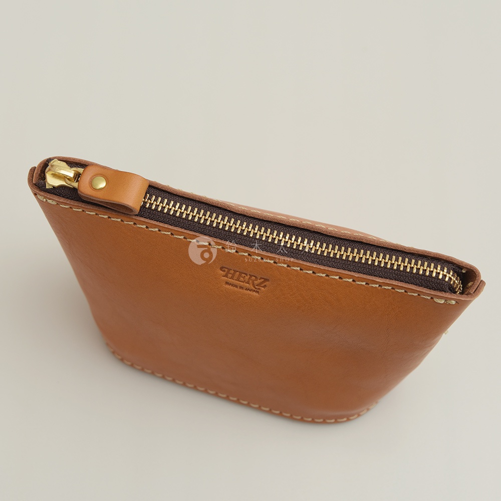 職人手作皮革三角收納包，淺棕色，採用天然皮革製作，搭配金色拉鍊。包身有精緻的縫線細節，並壓印有品牌標誌。